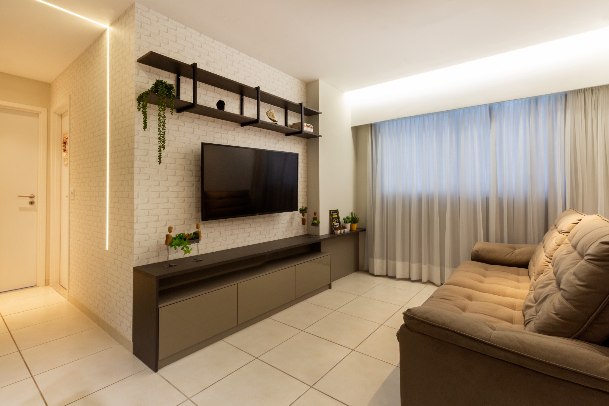 Sala de estar acolhedora com painel de televisão e iluminação indireta