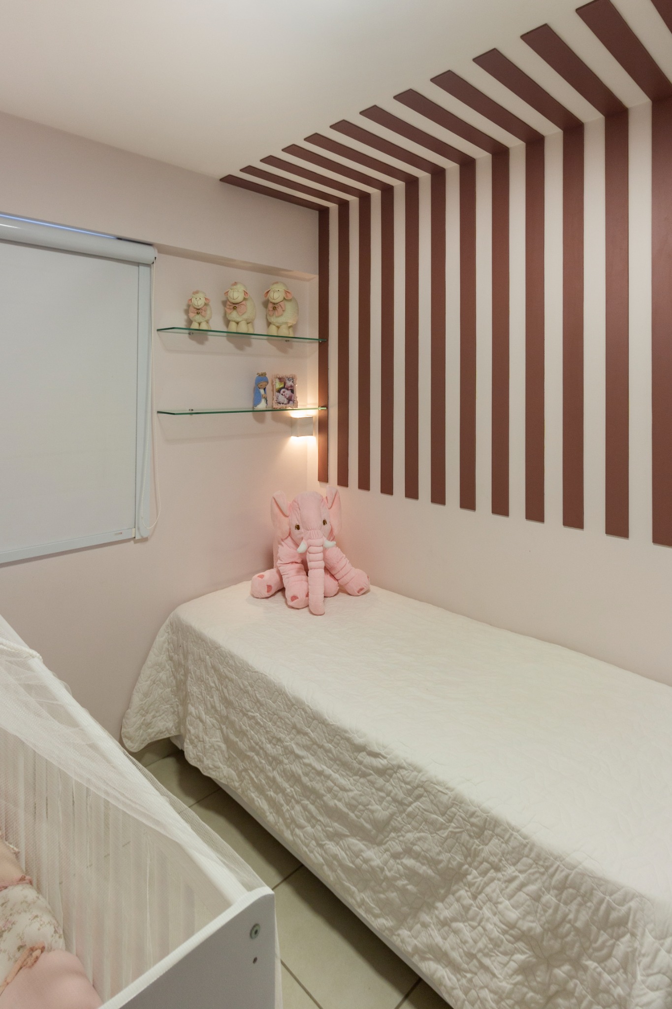 Quarto infantil com cama, berço e detalhe de marcenaria no teto