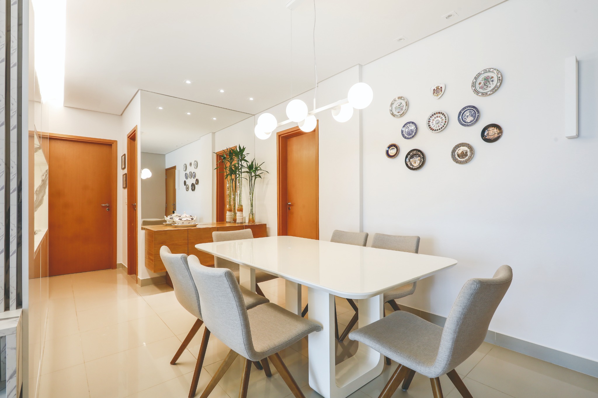 Sala de jantar com espelho e coleção afetiva de pratos decorativos