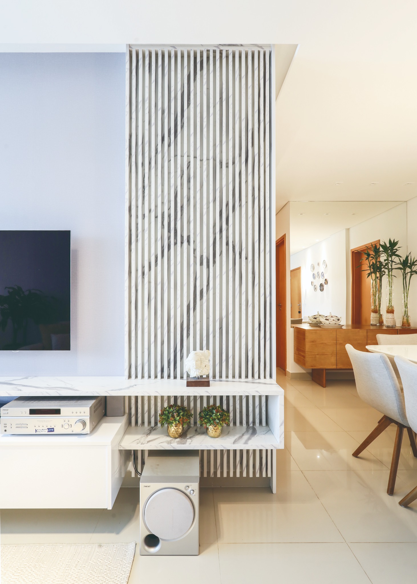 Detalhe do painel de televisão com ripado de efeito marmorizado
