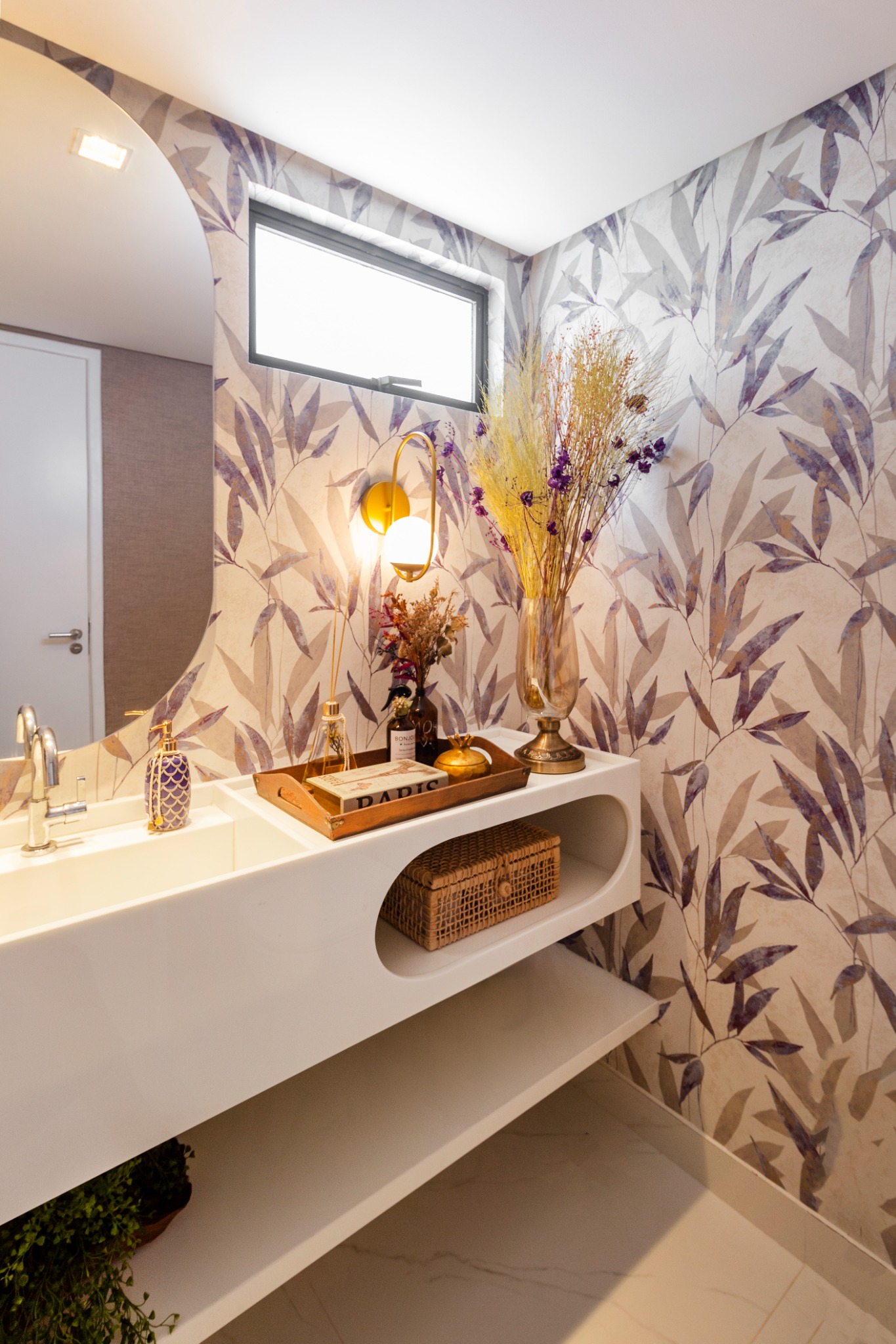 Detalhe do lavabo com iluminação decorativa e espelho orgânico